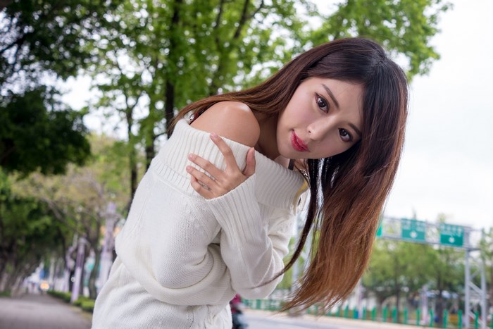 Young Woman Outdoors in White Sweater