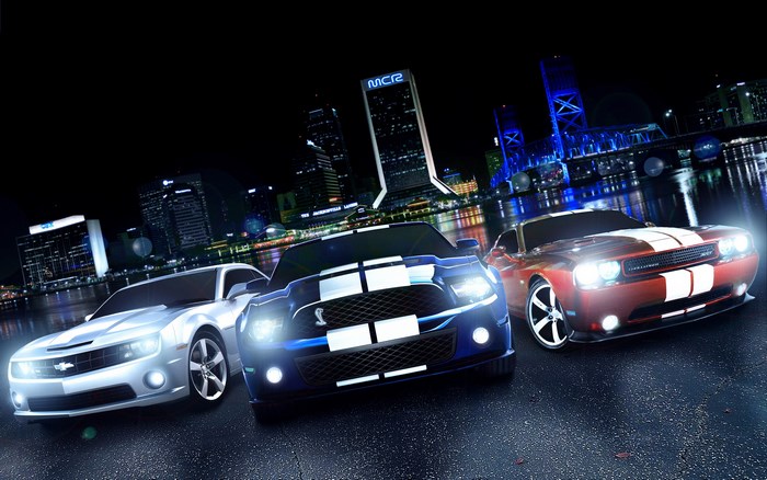 Three muscle cars in a city at night