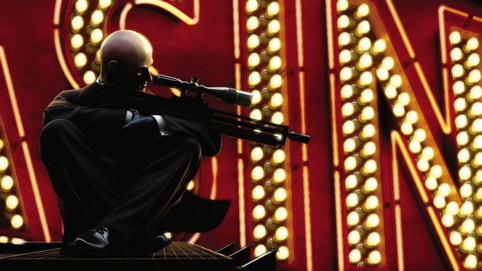 Agent 47 with sniper rifle in front of neon sign