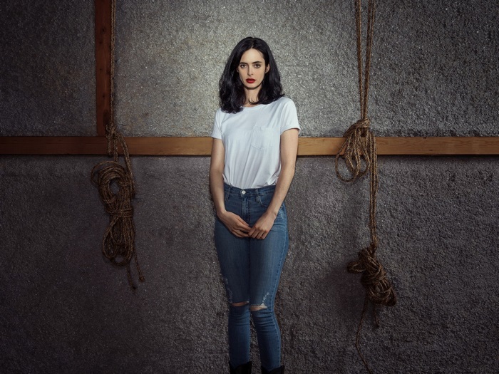 Jessica Jones in white t-shirt and ripped jeans