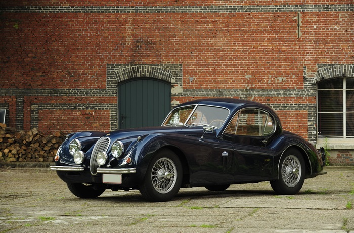 Jaguar XK120 coupe in front of a brick building