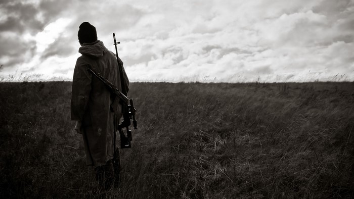 Sniper with rifle in field