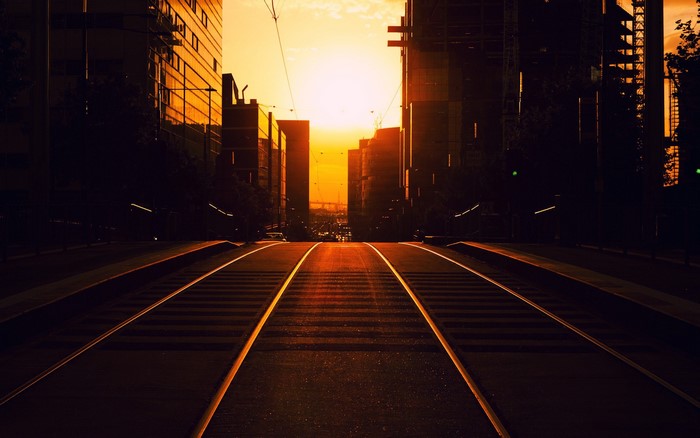 Tram tracks in a city during golden hour sunset