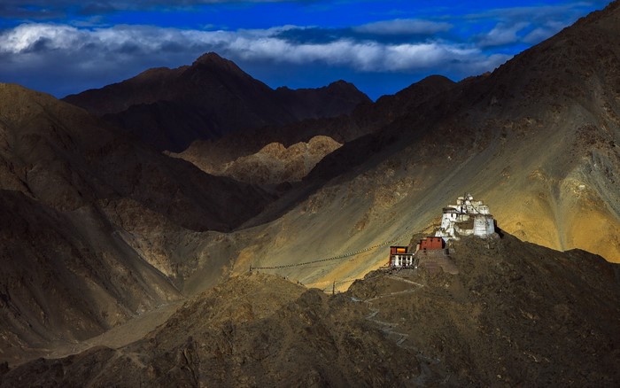 Monastery on a mountain ridge under dramatic clouds