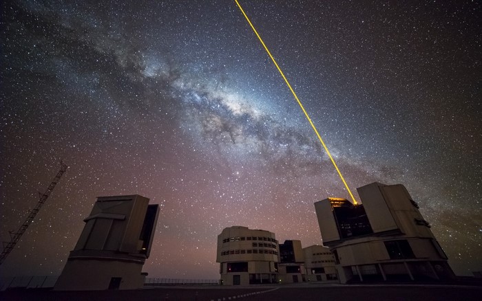 Observatory buildings under the Milky Way with a laser