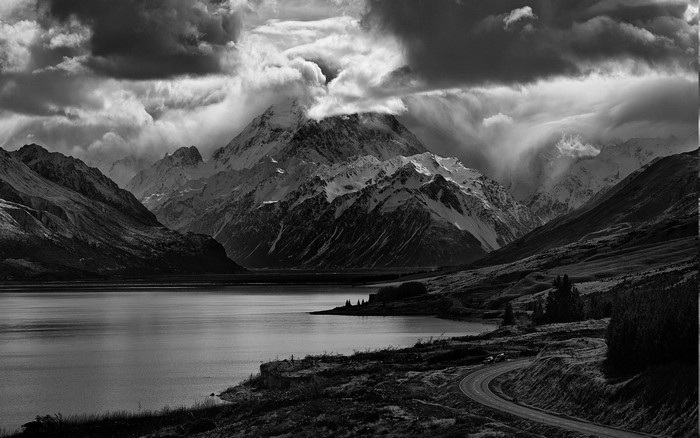 Monochrome mountain landscape with lake and road