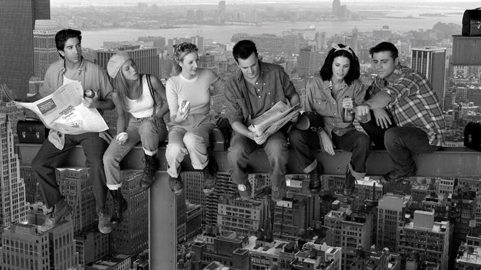 Friends TV series cast sitting on a beam