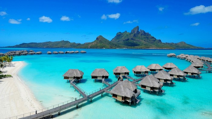 Overwater bungalows in Bora Bora lagoon with mountains