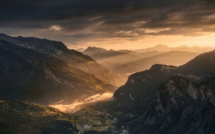 Mountain valley with sun rays and mist