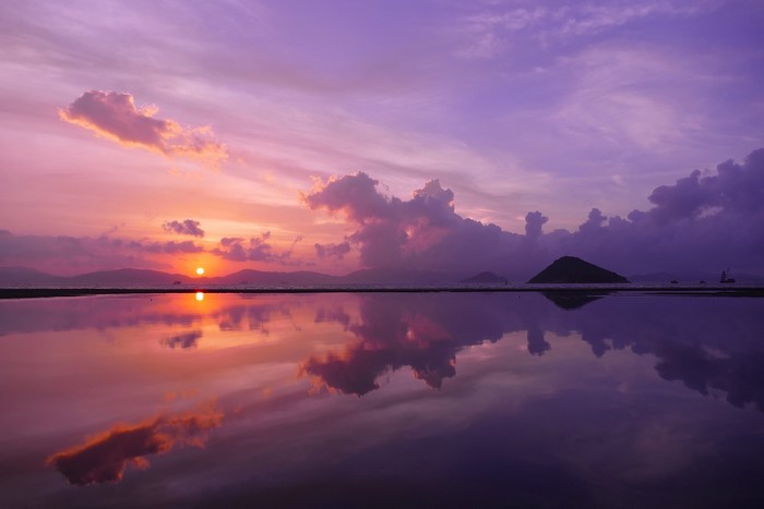 Sunset over water with island reflection