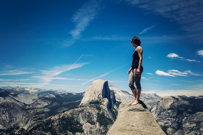 Woman on a cliff overlooking Yosemite National Park