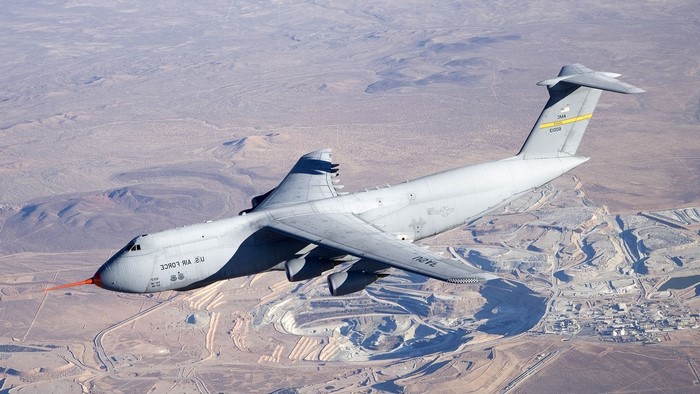 Lockheed C-5 Galaxy aircraft flying over desert landscape