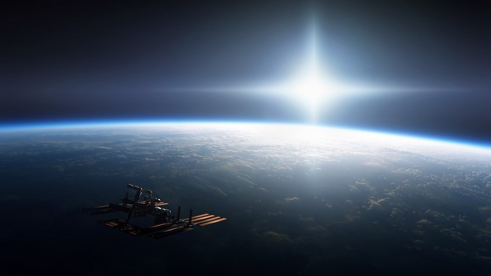 Space ISS orbiting Earth with bright sun