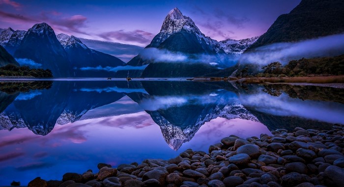 Mountain reflection in Milford Sound, New Zealand at sunrise