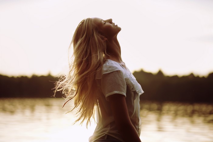 Woman with blonde hair looking up at the sky