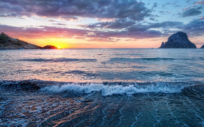 Sunset over the sea with a rocky island