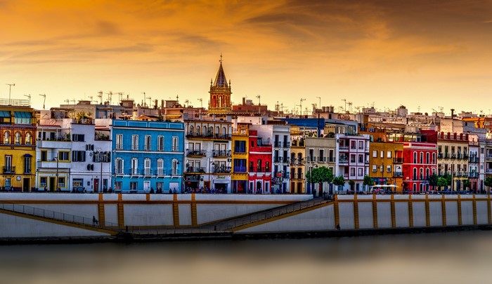 Colorful buildings along a river at sunset