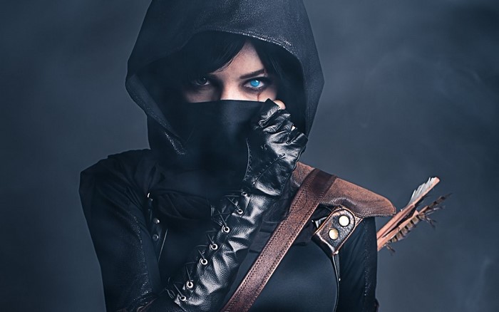 Woman in ninja costume with blue eyes and arrows