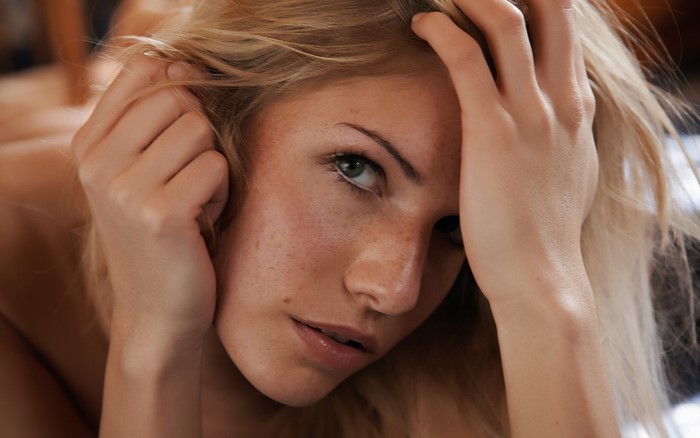 Woman with freckles touching her hair