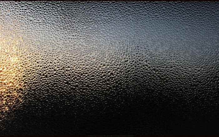 Textured glass with sunlight and dark background