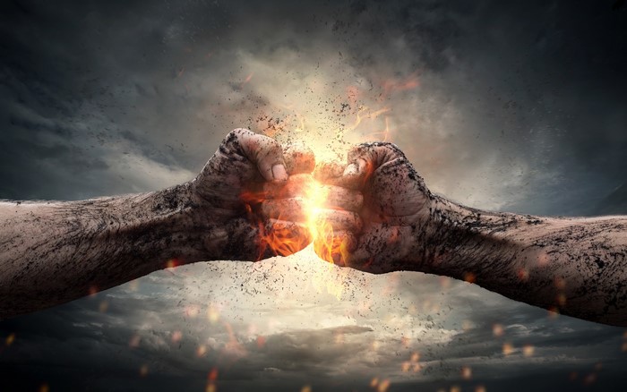 Two dirty fists colliding with fire and sparks