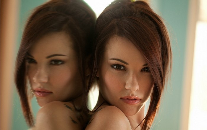 Woman with brown hair and eyes reflected