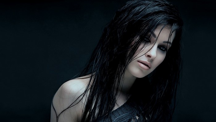 Woman with dark wet hair and dark eye makeup