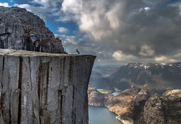 Person doing a handstand on a cliff in Norway