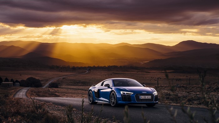 Blue Audi R8 on a winding road at sunset
