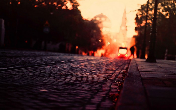 Cobblestone street with tram at sunset