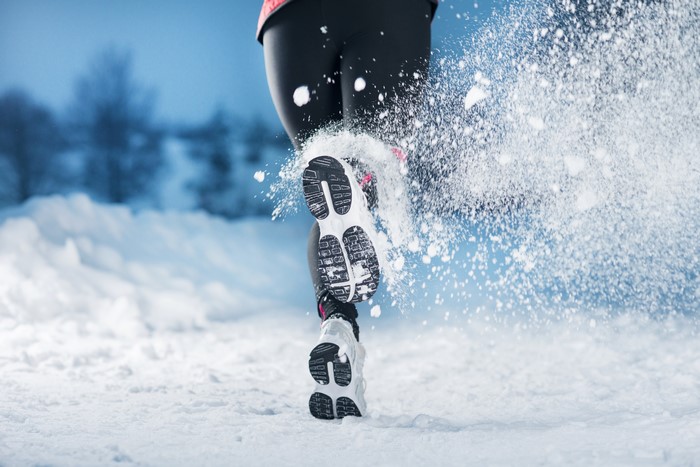 Runner kicking up snow in winter