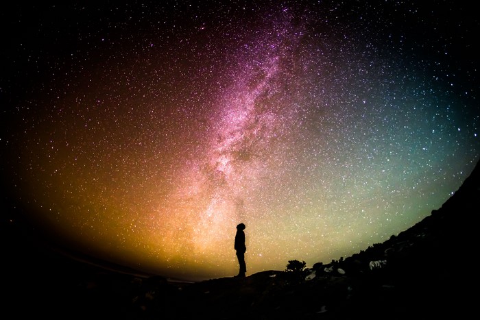 Person looking at the colorful Milky Way galaxy