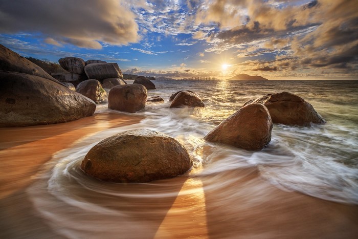 Sunset Over Rocky Beach with Flowing Waves