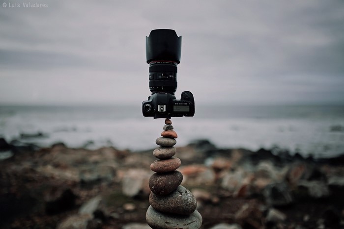 Camera balanced on stacked rocks by the sea