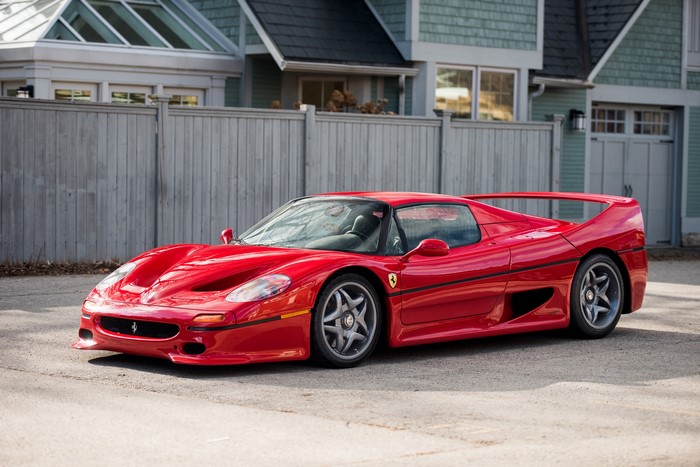 Red Ferrari F50 parked in front of a house