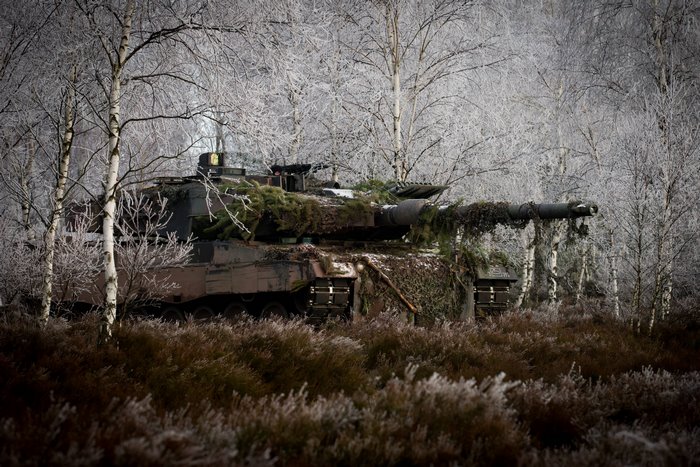 Leopard 2 tank camouflaged in a frosty forest