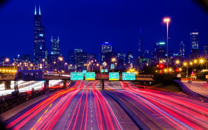 Chicago highway at night with light trails and cityscape