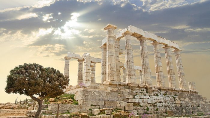 Temple of Poseidon ruins with sun rays