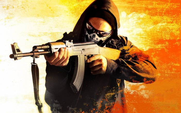 Man in hoodie and skull mask holding AK-47
