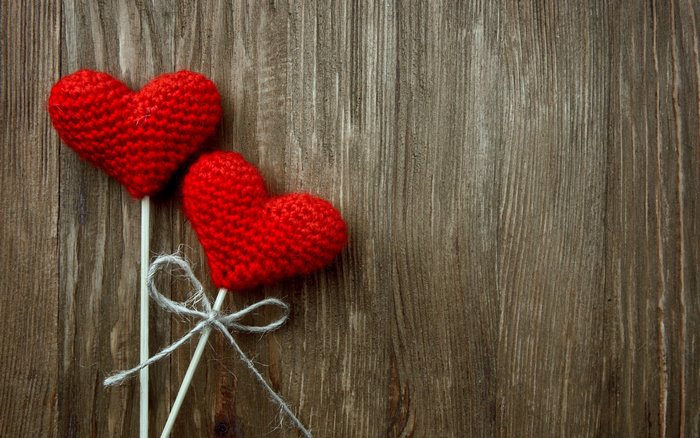 Two red crochet hearts on sticks with twine
