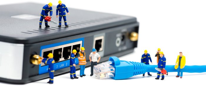 Miniature workers repairing a network router and cable