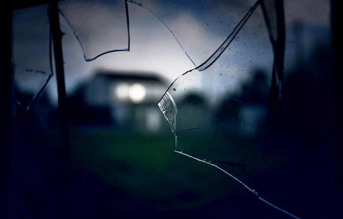 Broken glass in front of a house at dusk