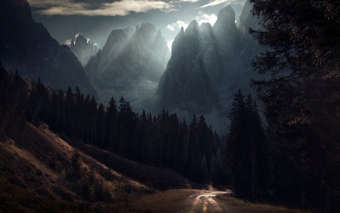 Dark Mountain Peaks with Sunbeams and Forest