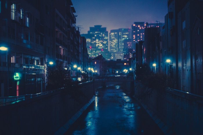 Night cityscape with river and illuminated buildings in Japan