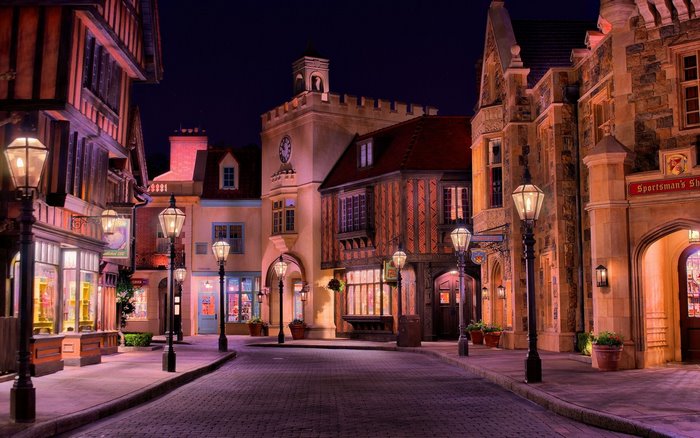 European street at night with lampposts and shops