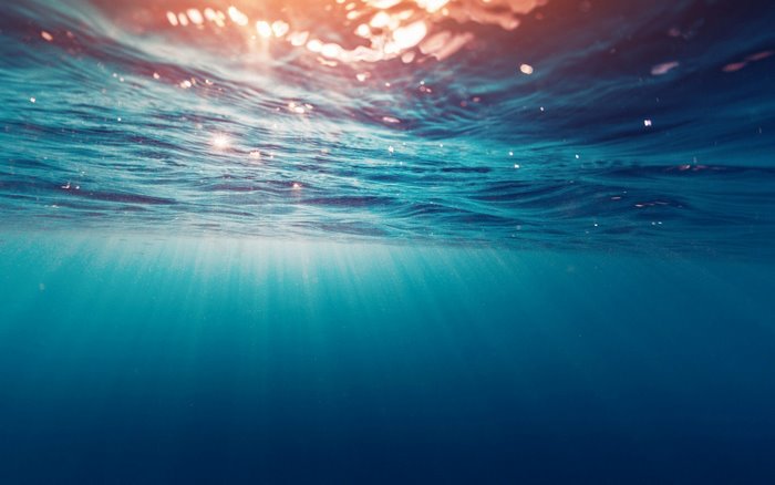 Underwater sun rays piercing the ocean surface
