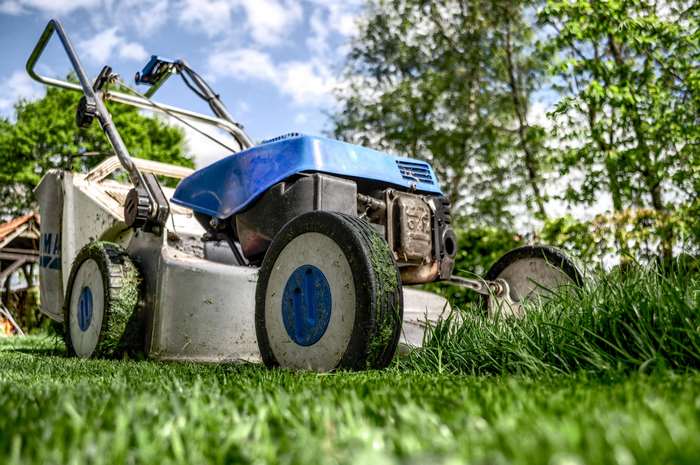 Lawn mower cutting grass in a garden 4K