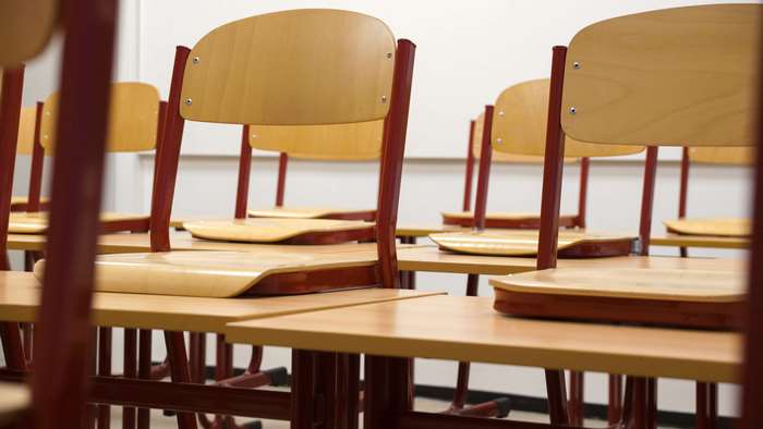 Empty classroom with wooden chairs and desks