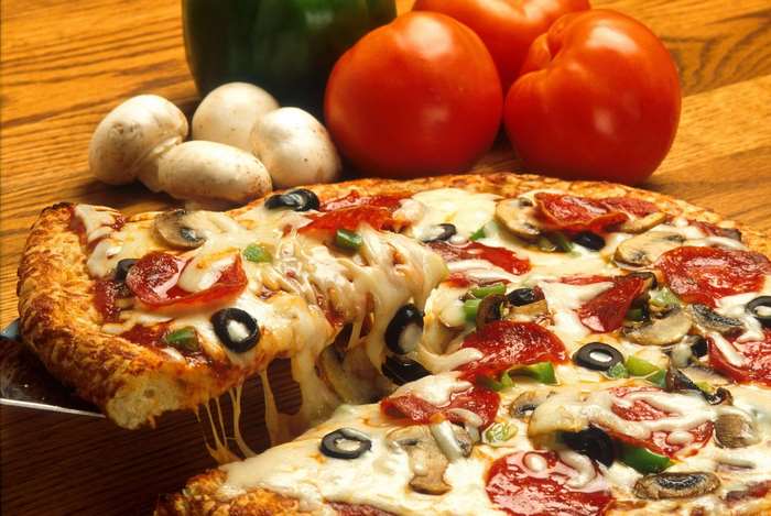 Delicious pizza with pepperoni, mushrooms, olives, and vegetables