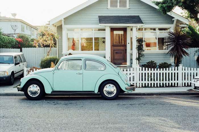 Mint green Volkswagen Beetle parked in front of a house